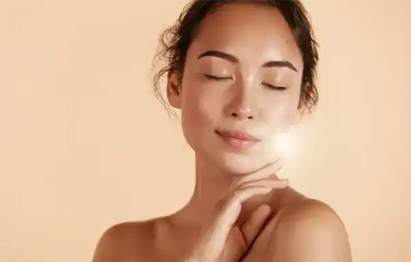 A woman with her eyes closed in bliss, enjoying the newfound glow on her face.