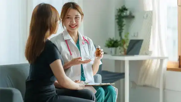 A smiling doctor is recommending a product to a patient.